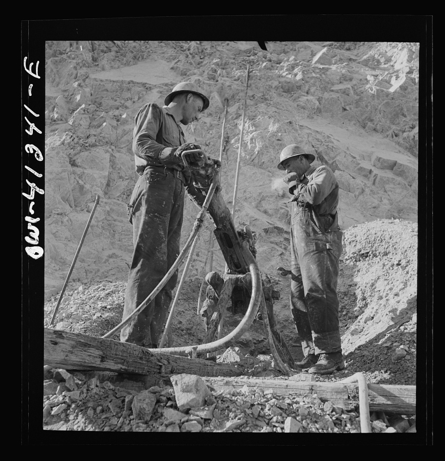Miners drilling the bench face of an open pit.