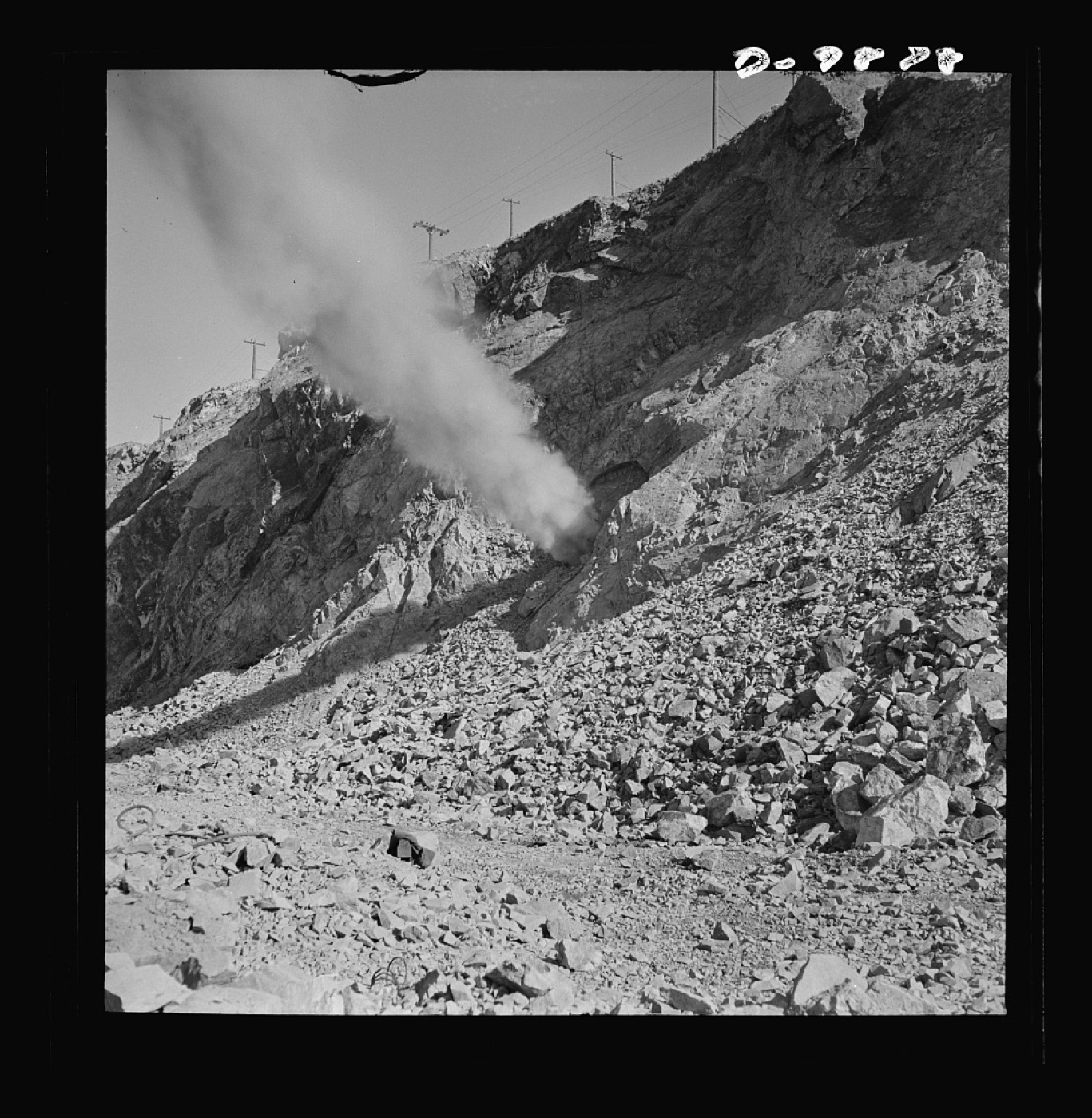 A charge firing off an open-pit mine wall.
