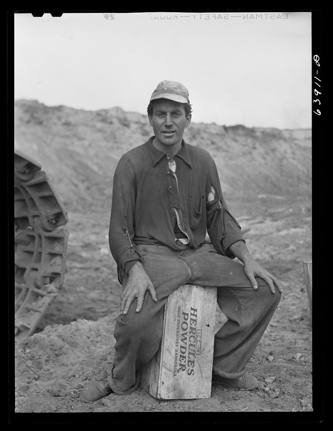 Powderman preparing charges at a mine bench.